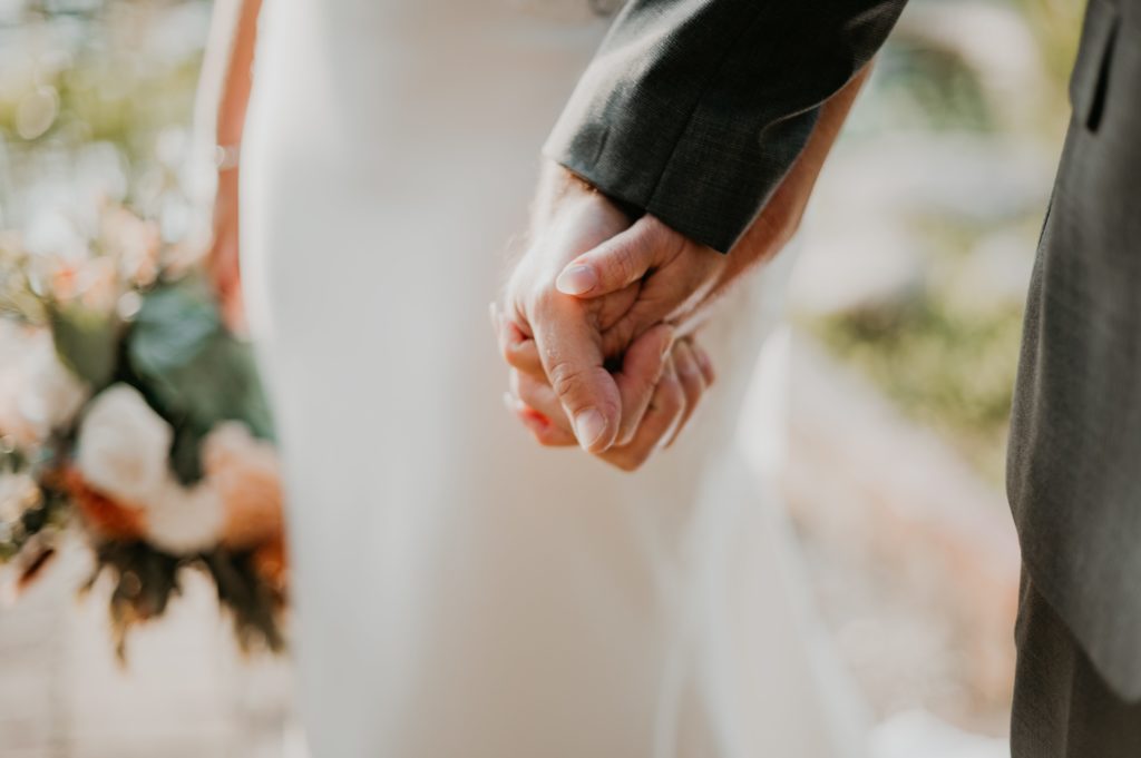 Bride and Groom holding hands after intimate garden wedding