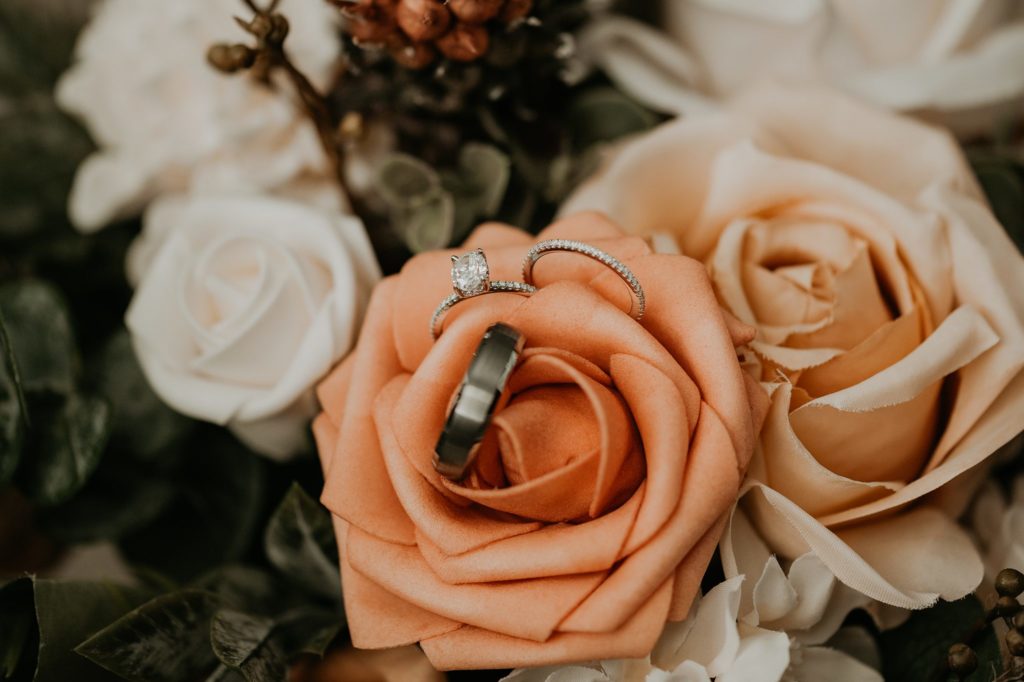 Bride and Groom wedding rings in blush and white bouquet at garden intimate wedding greenhouse